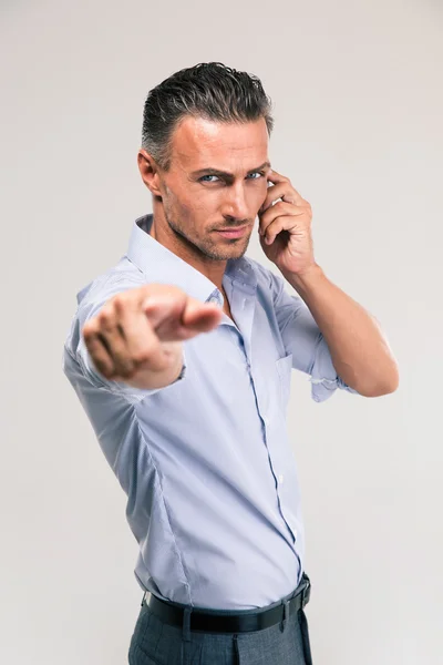 Geschäftsmann telefoniert und zeigt auf Kamera — Stockfoto