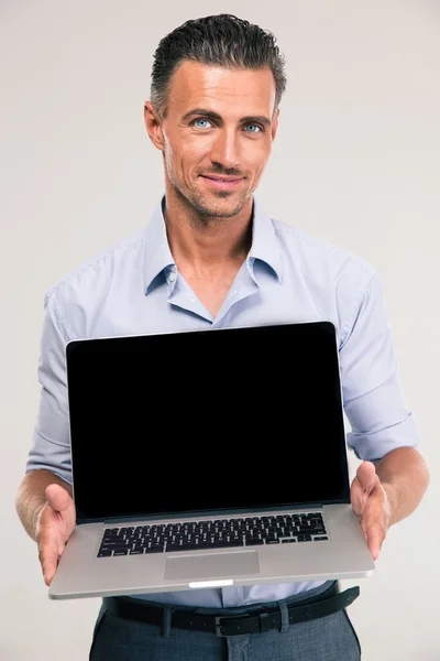 Businessman showing blank laptop computer screen — Stock Photo, Image