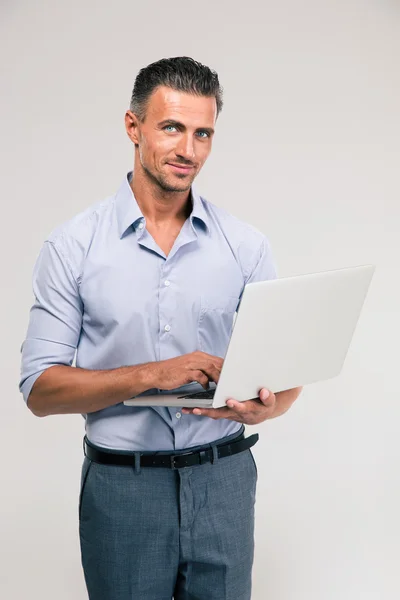 Portret van een gelukkig zakenman met behulp van laptop — Stockfoto