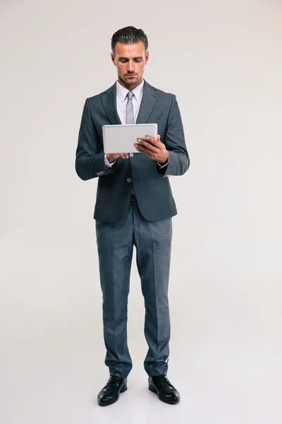Уверенный бизнесмен с помощью планшетного компьютера — стоковое фото