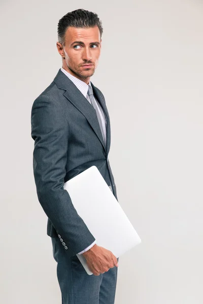 Pensive businessman holding laptop computer — Stock Photo, Image