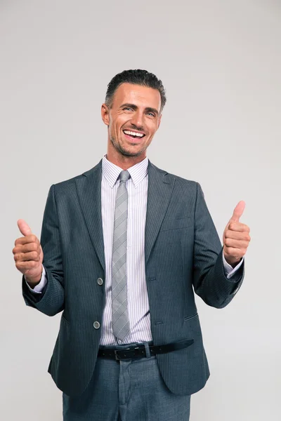 Hombre de negocios sonriente mostrando pulgares hacia arriba —  Fotos de Stock