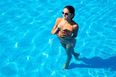 Yüzme havuzunda duran güzel kadın 