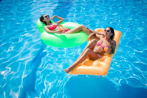 Les filles se reposent sur un matelas gonflable dans la piscine — Photo