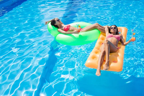 Meninas descansando no colchão de ar na piscina — Fotografia de Stock