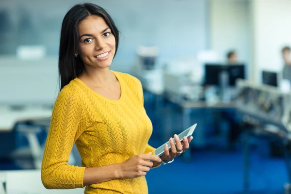 Empresária de pé com computador tablet no escritório — Fotografia de Stock