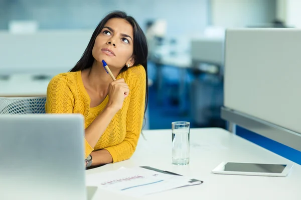 Empresária pensativa sentada no seu local de trabalho — Fotografia de Stock