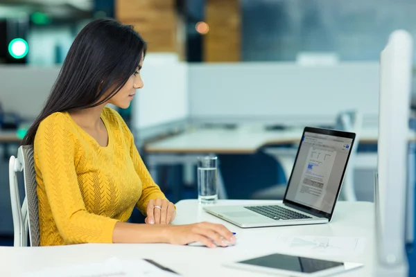 Businesswoman using laptop in office — Stock Photo, Image