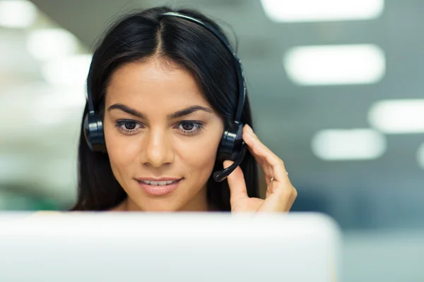 Zakenvrouw bezig met laptop met koptelefoon — Stockfoto