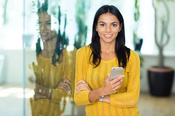Mujer de negocios sonriente sosteniendo smartphone — Foto de Stock