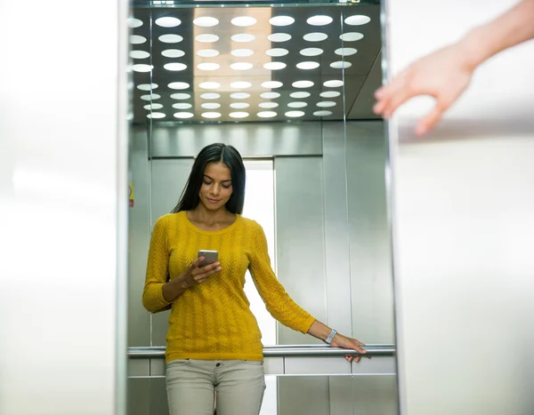 Geschäftsfrau benutzt Smartphone im Aufzug — Stockfoto