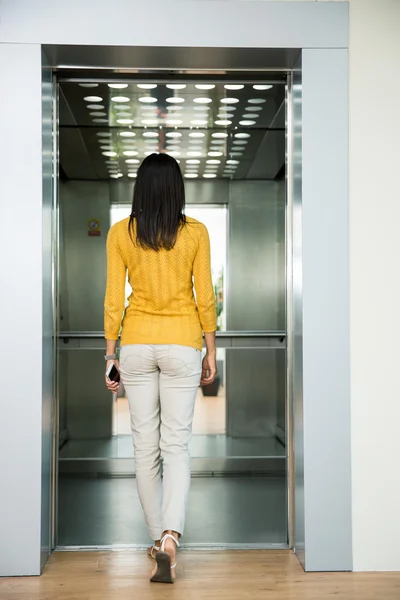 Voltar vista retrato de uma mulher que vai no elevador — Fotografia de Stock