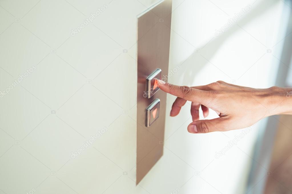 Female finger pushing elevator button