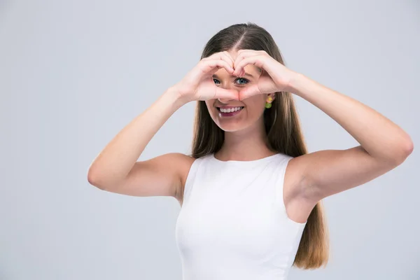 Smiling female teenager showing heart gesture with fingers — Stock Photo, Image