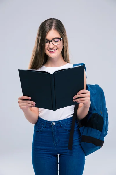 Retrato de una adolescente sonriente leyendo un libro — Foto de Stock