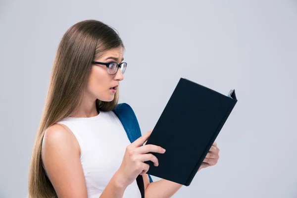 Verbaasd vrouwelijke tiener lezen van boek — Stockfoto