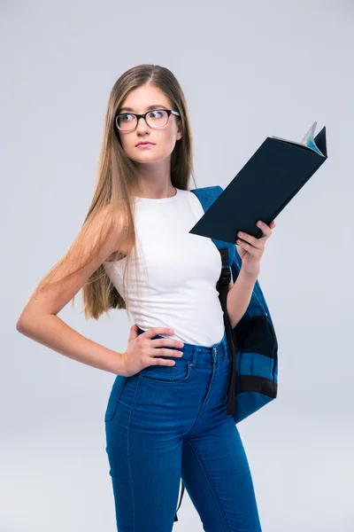 Nadenkend vrouwelijke tiener boek houden en weg op zoek — Stockfoto