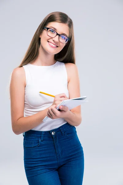 Vrouwelijke tiener schrijven nota's in notitieblok — Stockfoto