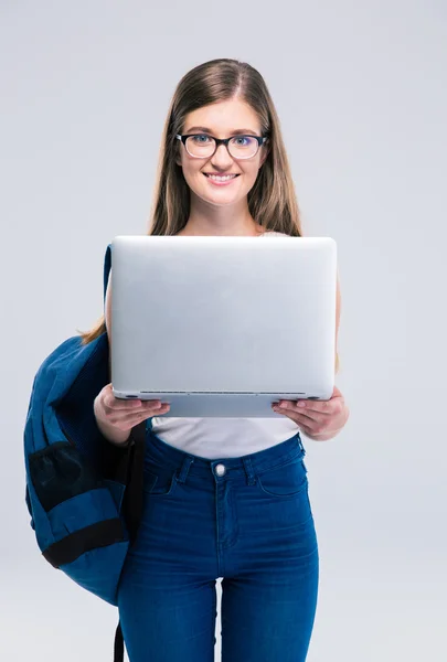 Lachende vrouwelijke tiener permanent met laptop — Stockfoto