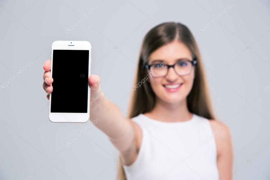 Female teenager showing blank smartphone screen 