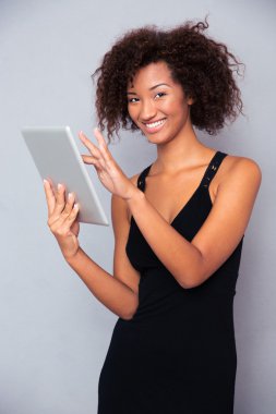Tablet bilgisayar kullanan gülümseyen Afrika kadın 
