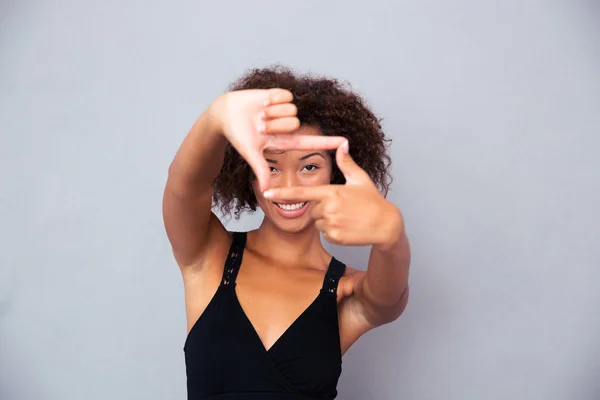 Africano donna guardando fotocamera attraverso cornice gesto — Foto Stock