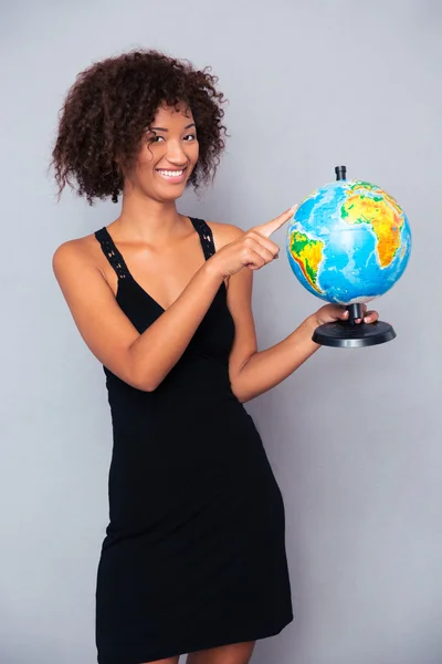 Счастливая африканская женщина держит глобус — стоковое фото