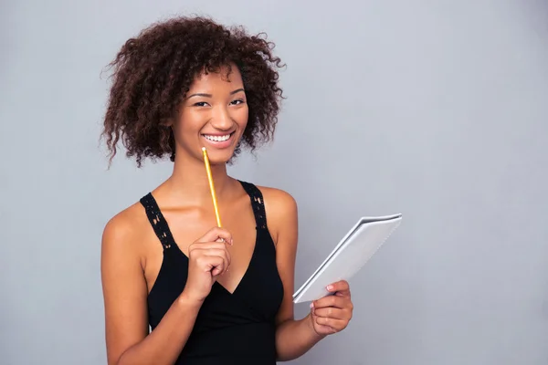 Afro-americana segurando caderno com lápis o — Fotografia de Stock