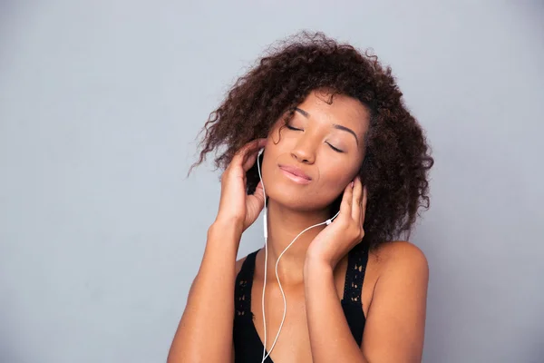 Afro amerikansk kvinna lyssnar musik i hörlurar — Stockfoto