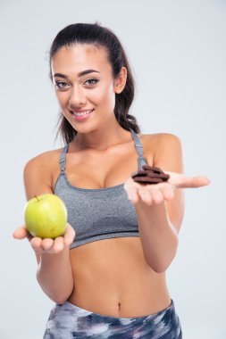 Gülümseyen kız elma ve çikolata arasında seçim yapma