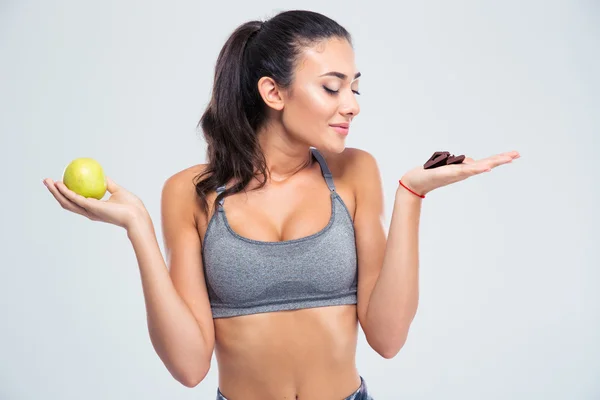 Mädchen hat die Wahl zwischen Apfel oder Schokolade — Stockfoto