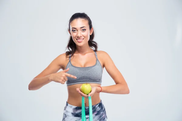 Sportowe kobieta palcem wskazującym na jabłko i pomiarowe typ jest — Zdjęcie stockowe