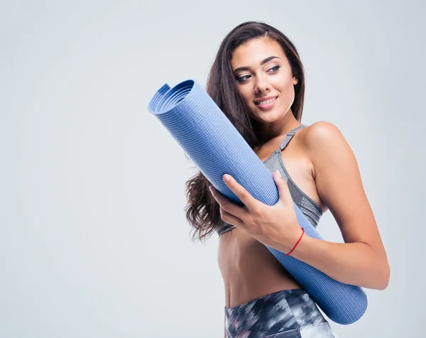 Улыбающаяся спортивная женщина с ковриком для йоги — стоковое фото