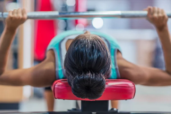 Entrenamiento de mujer con barra en el banco — Foto de Stock