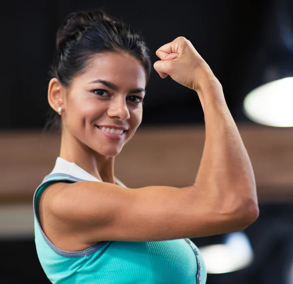 Vrouw haar biceps in gym tonen — Stockfoto