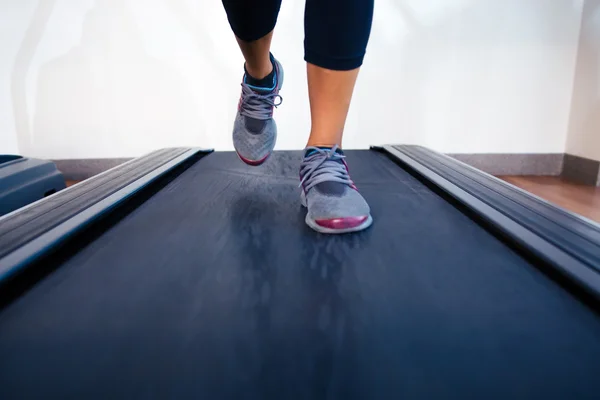 Ženské nohy běží na běžeckém pásu — Stock fotografie