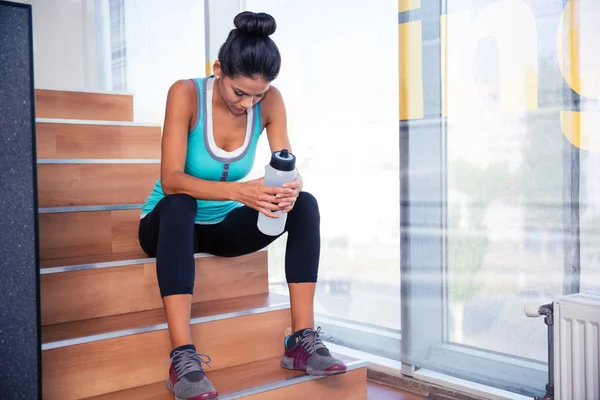 Müde Sportlerin sitzt auf der Treppe — Stockfoto