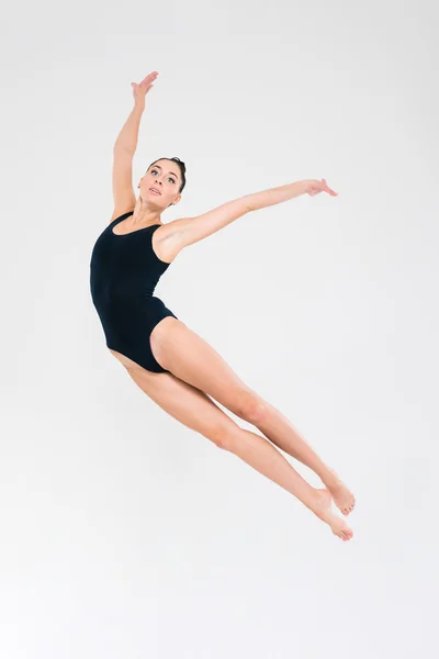 Kvinna i gymnast kostym gör akrobatiska trick — Stockfoto