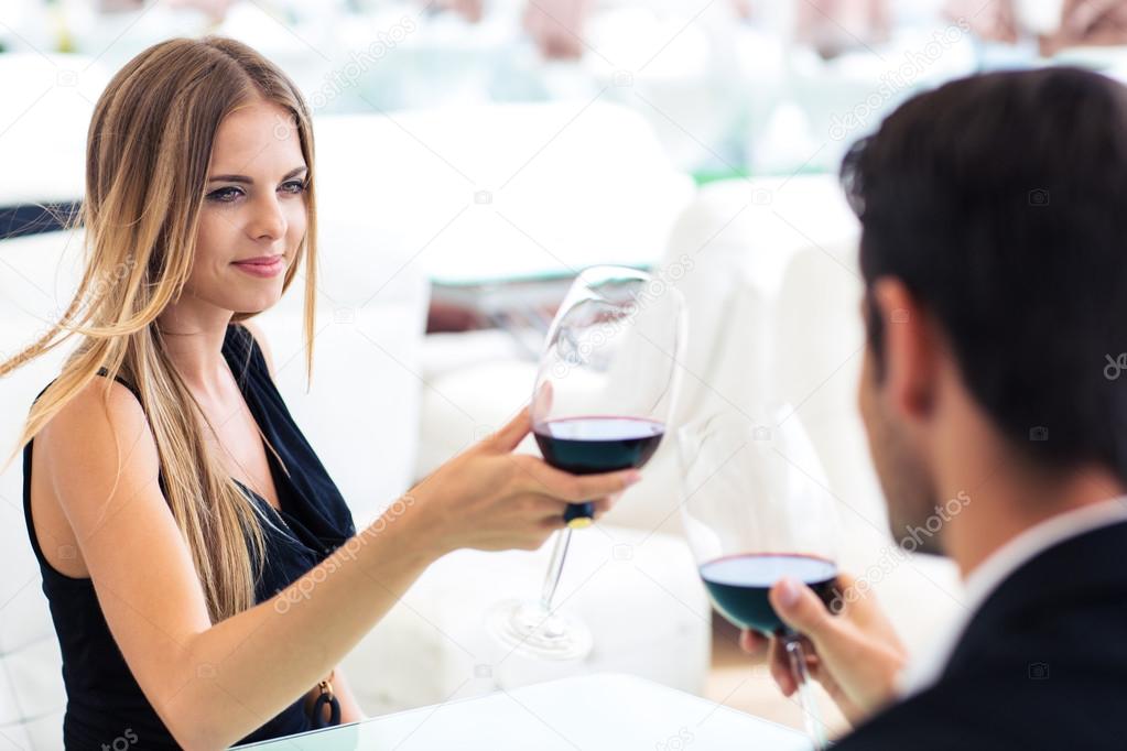 Woman drinking red wine with boyfriend