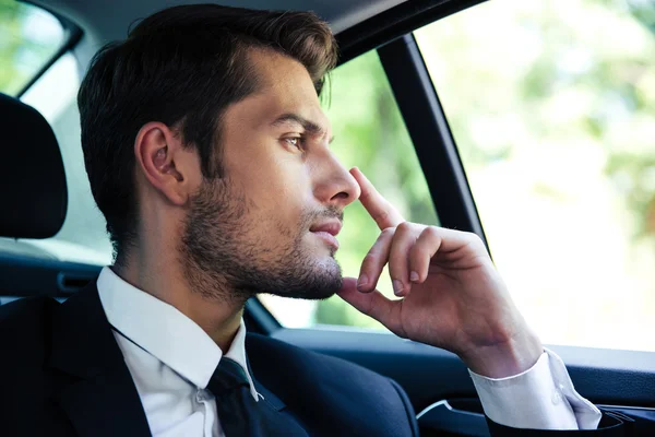 Businessman riding in car — Stock Photo, Image