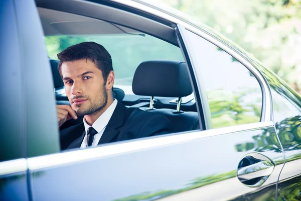 Geschäftsmann blickt auf Fenster im Auto — Stockfoto
