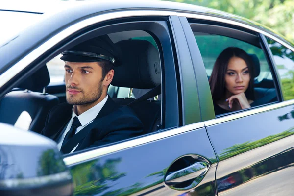 Woman riding in a car with chauffeur — Stock Photo, Image