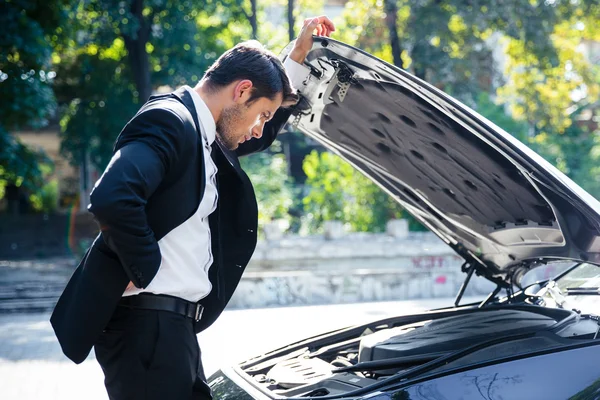 Hombre de pie cerca de coche roto — Foto de Stock