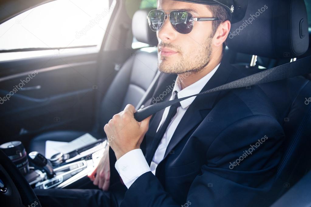 Male chauffeur sitting in a car