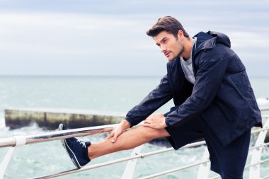 Açık havada bacaklar uzanan sporcu 