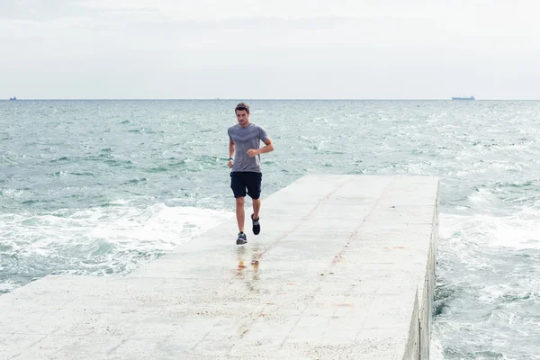 Человек, бегущий по пляжу — стоковое фото