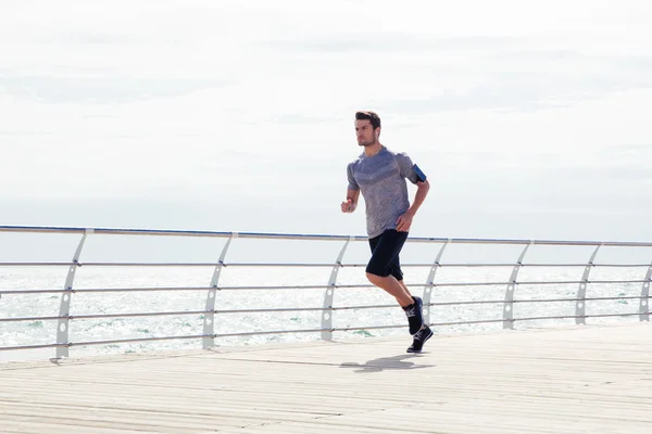 Спортивный человек, бегущий на открытом воздухе возле моря — стоковое фото