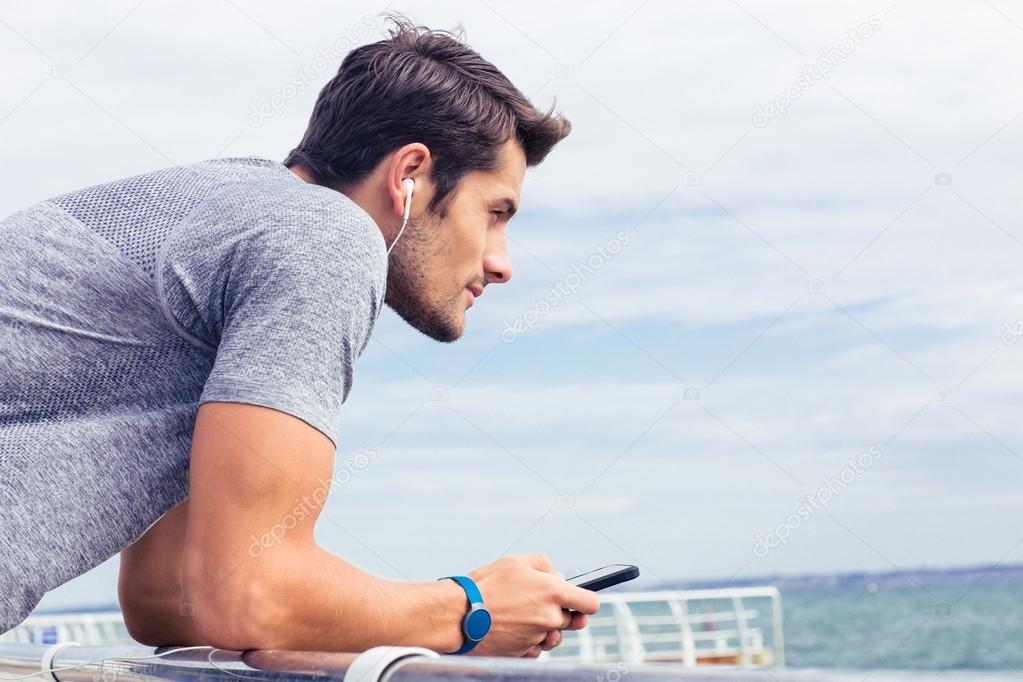 Sports man standing near sea outdoors