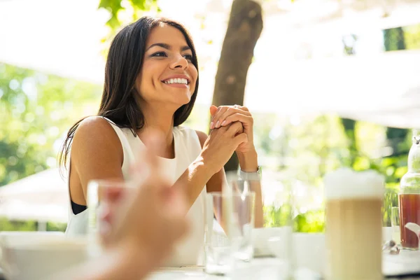 Женщина, сидящая за столом в открытом ресторане — стоковое фото