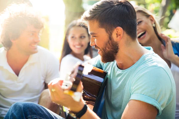 Friends with guitar having fun outdoor Stock Photo